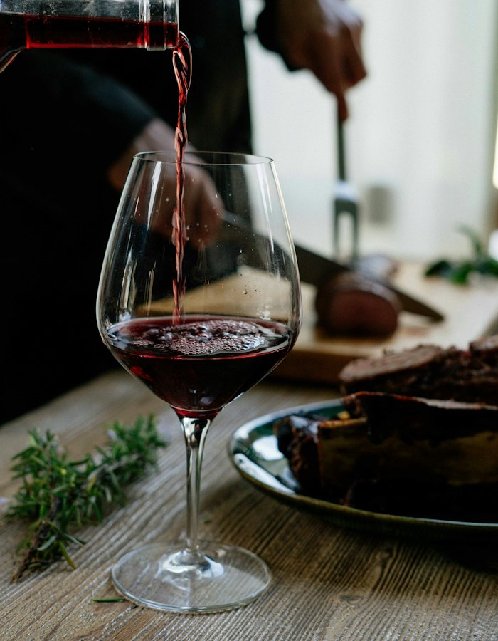 Red wine being poured into a glass.
