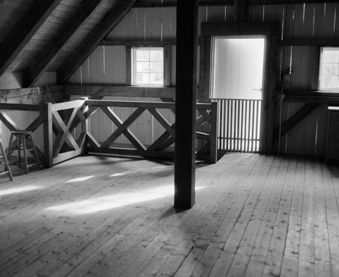 The empty loft in 2017: bare plank floors, a single post and light from two small windows.