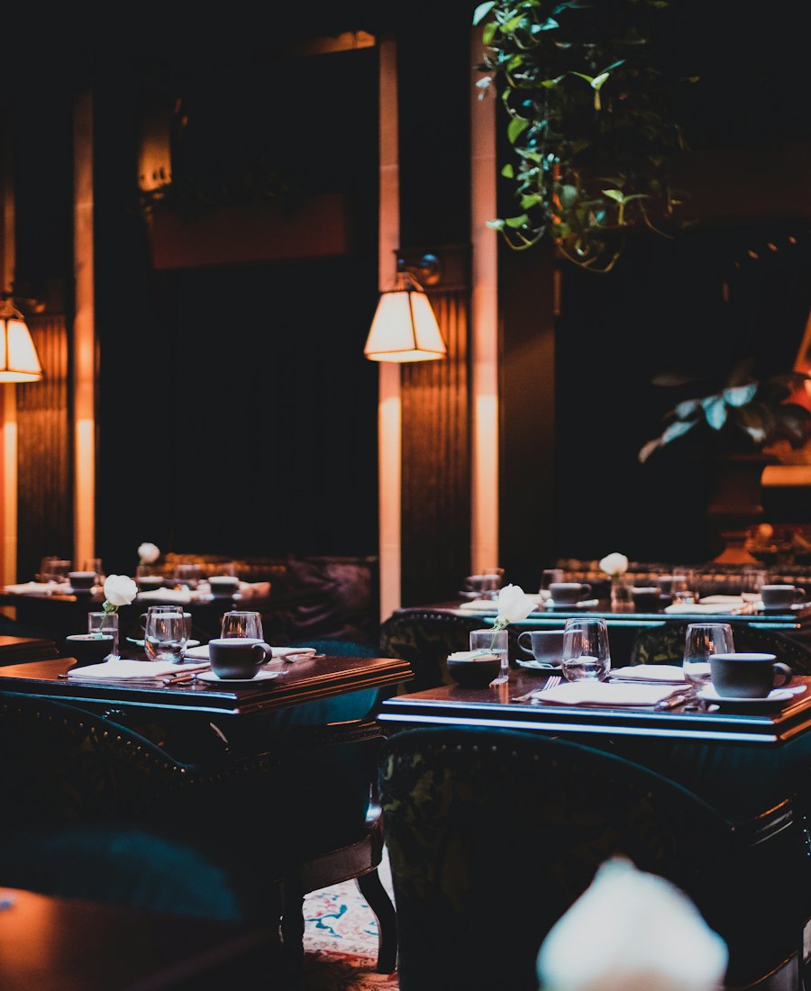 The dining room at night, low lamps over the tables.