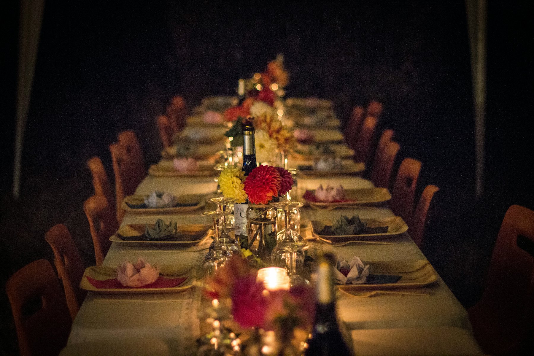 One long table set for a private dinner, candles and flowers down the middle.